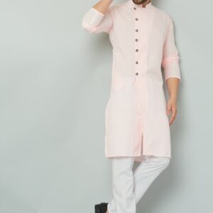 Indian man wearing pink kurta and white pants.